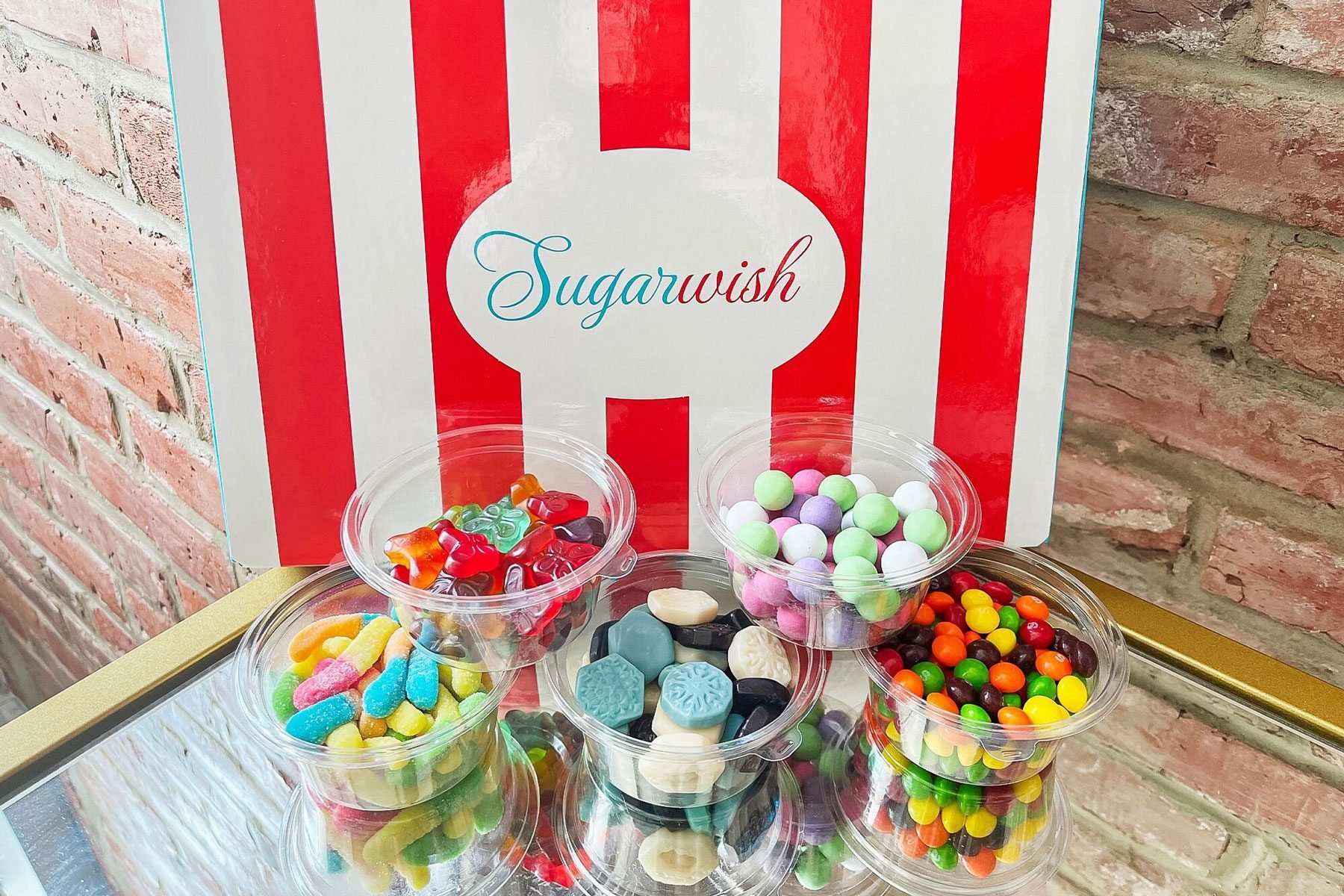 Image showing a red and white striped bag with a selection of five different candies sitting in front of it in small containers