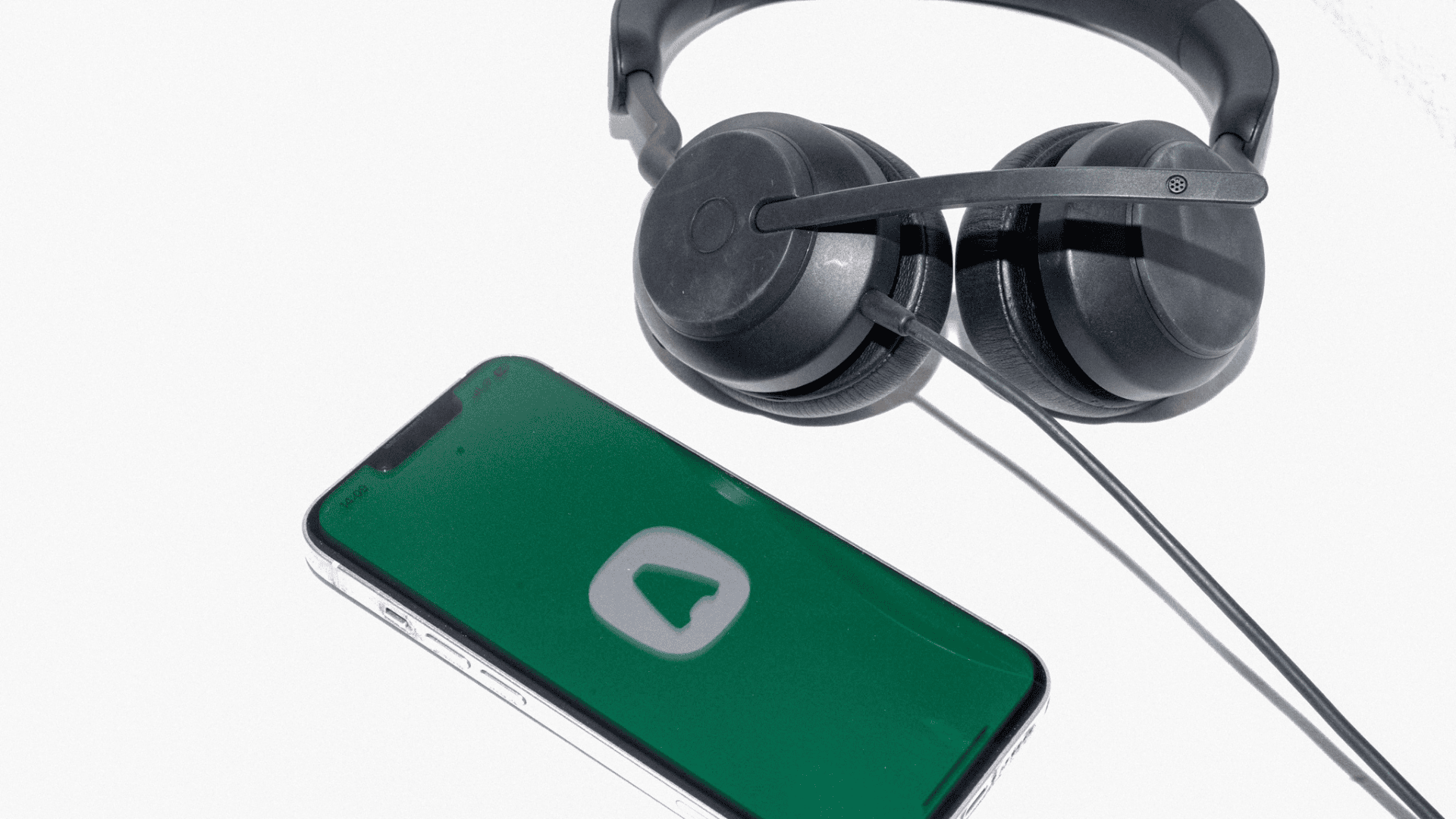 Black headphones next to smartphone displaying Aircall, a green app interface with white logo.