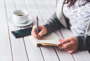 person sitting down taking notes in a notebook